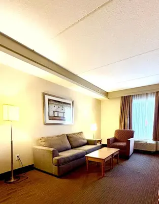 a living room with a couch and a chair at Waterloo Suites Hotel, Trademark Collection by Wyndham in Waterloo