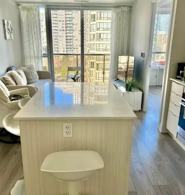 a kitchen with a large island in a living room at Modern & Stylish Condo Downtown in Mississauga