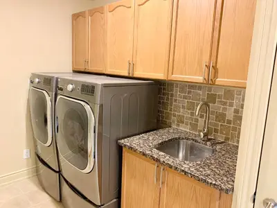 a kitchen with a washing machine and a sink at Private Bright Coach House - Near Pearson Airport & Downtown Toronto in Brampton