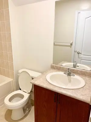 a bathroom with a sink and a toilet and a mirror at Private Bright Coach House - Near Pearson Airport & Downtown Toronto in Brampton