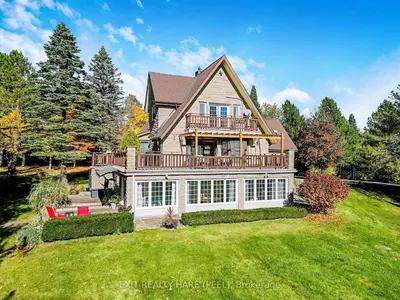 a large house with a deck on a lawn at Mono Farmhouse in Caledon