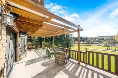 a wooden deck with chairs and a pergola at Mono Farmhouse in Caledon