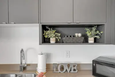 a kitchen with white cabinets and potted plants on a counter at Ritzy 3BR Home with Balcony Near Burlington Pier in Burlington