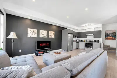 a living room with a couch and a tv at Ritzy 3BR Home with Balcony Near Burlington Pier in Burlington