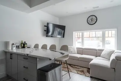 a living room with a couch and a clock on the wall at Luxury 2 Bedroom 3 Bed Family Friendly Oasis with Smart Technology in Brampton