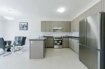 a large kitchen with stainless steel appliances and cabinets at Entire 4BR Detached Home 15 Mins from the Falls, in Thorold, Perfect for 10 guests in Thorold