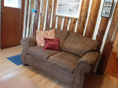 a brown couch sitting in a living room at Wymbolwood Lodge in Tiny