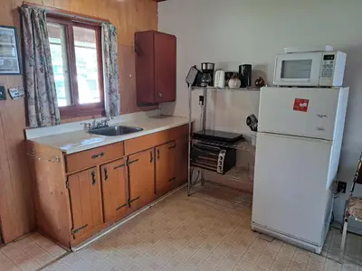 a kitchen with a white refrigerator and a microwave at Wymbolwood Lodge in Tiny