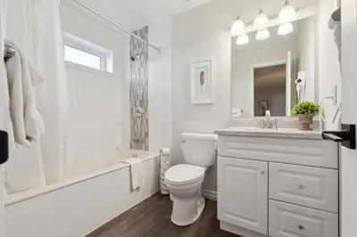 a white bathroom with a tub and a toilet and a sink at Wintergreen Spacious 2 Story Townhome Sauna 2 Min Walk to Village in Blue Mountains