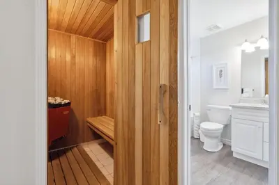 a bathroom with a toilet and a wooden wall at Wintergreen Spacious 2 Story Townhome Sauna 2 Min Walk to Village in Blue Mountains
