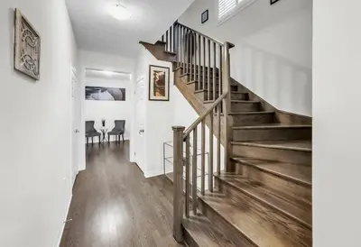 a staircase in a home with white walls and wooden floors at Modern Comfort in Clarington in Newcastle