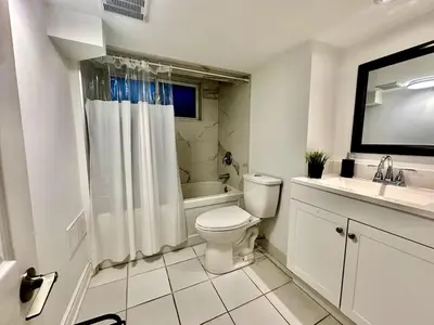 a white bathroom with a toilet and a sink at Comfortable place In An Amazing Location in Toronto