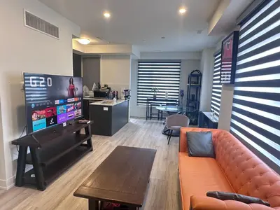 a living room with a couch and a flat screen tv at 2bedroom Townhome in South Richmond Hill in Richmond Hill