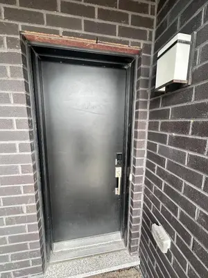 a metal door on a brick wall with a light at 2bedroom Townhome in South Richmond Hill in Richmond Hill