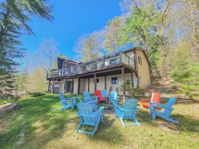 a group of blue chairs in front of a house at Villa Marina Haven private Waterfront in Port Carling