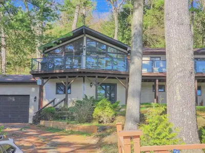 a house with a glass house with a tree at Villa Marina Haven private Waterfront in Port Carling