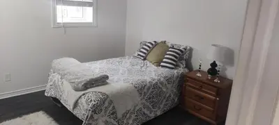 a bedroom with a bed and a table with a lamp at Sartawi Place -Studio at Georgian Bay in Waubaushene