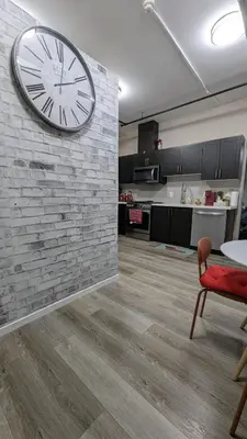 a large clock on a brick wall in a living room at The Downtown Gem Toronto in Toronto