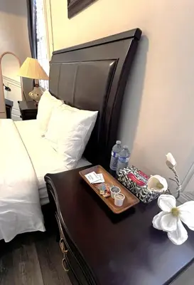a bed with a tray of water bottles on a table at The Downtown Gem Toronto in Toronto