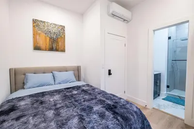 a bedroom with a bed and a painting on the wall at Adorable Modern Master Bedroom near Colleges and K-town in Toronto