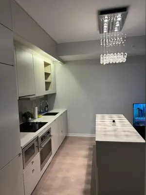 a kitchen with white cabinets and a chandelier at Cozy 1 Bedroom Downtown in Toronto