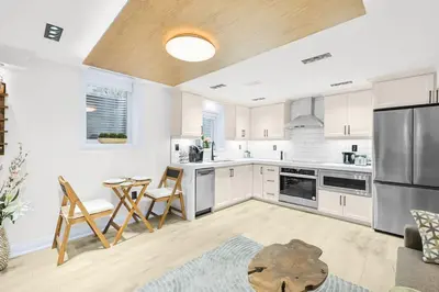 a kitchen with white cabinets and a table and chairs at Pinnacle of Luxury & Leisure- 2 BDM,2 BATH, KITCHEN in Whitby