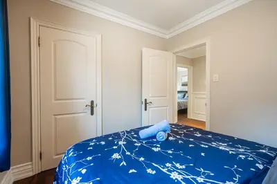 a bedroom with a bed with a blue bedspread with flowers at 3 Bedroom Luxury House in Toronto in Toronto