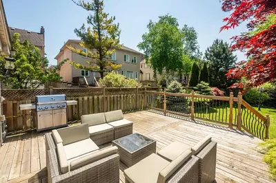a backyard with a wooden deck with chairs and a stove at 3 Bedroom Luxury House in Toronto in Toronto