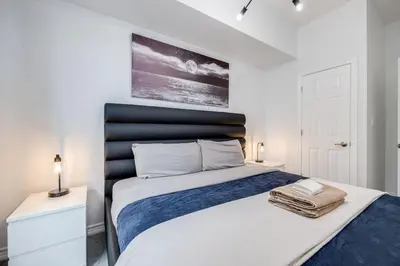 a bedroom with a large bed with a black headboard at Modern 1BR and 1BA condo near Downtown with City Views in Toronto