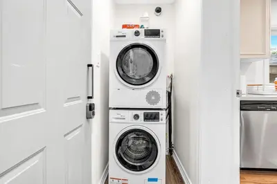 a washer and dryer in a kitchen next to a door at Cozy 2BR Home with Workspace Toronto Retreat in Toronto