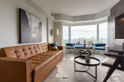 a living room with a couch and a table at Chic 1BR plus Den Condo Near ROM and CN Tower in Toronto