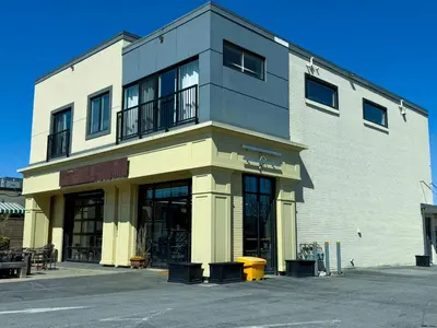 a large white building with a balcony on a street at Contemporary East Loft in Historic Niagara in Niagara on the Lake