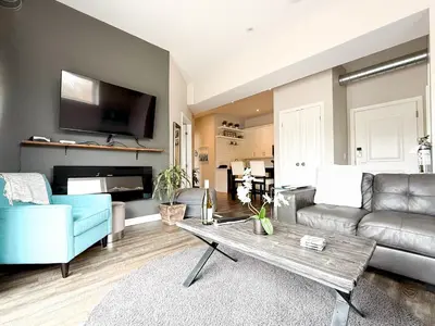 a living room with a couch and a table at Contemporary West Loft in Historic Niagara in Niagara on the Lake