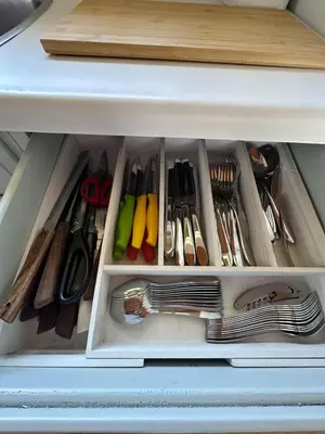 a drawer filled with utensils in a cabinet at Cozy lakeside Cottage on 3 Mile Lake with Wifi in Windermere