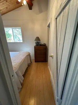 a bedroom with a bed and a dresser and a window at Cozy lakeside Cottage on 3 Mile Lake with Wifi in Windermere