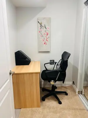 a desk with a black chair next to a computer at The Sleek Shelter in Milton