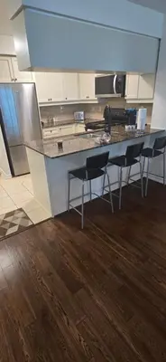 a kitchen with a counter and chairs in it at Lovely condo near Lake Ontario in Toronto