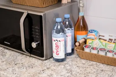 two bottles of soda sitting next to a microwave at Luxurious Home Away From Home in Pickering