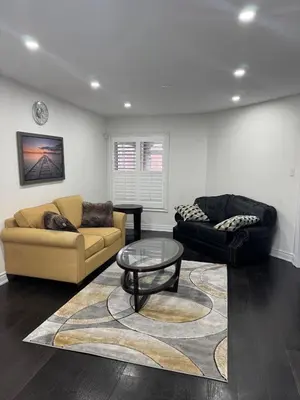 a living room with two couches and a coffee table at Pearson Gateway Comfort Home in Mississauga