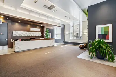 an office lobby with a reception desk and plants at Prime Downtown Condo - St Lawrence Parking in Toronto