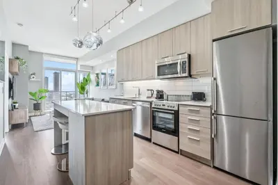 a kitchen with stainless steel appliances and wooden cabinets at Prime Downtown Condo - St Lawrence Parking in Toronto