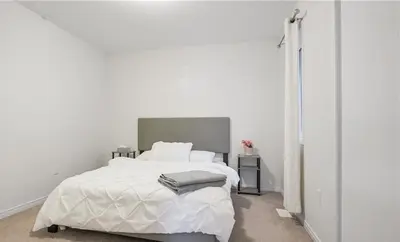 a white bedroom with a white bed and a window at Classy Home Near Beach & Airport in Hagersville