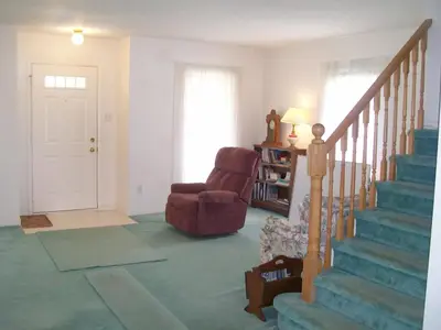 a living room with a chair and a stair case at Lakeshore North - Waterloo in Waterloo