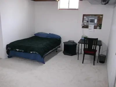 a small bedroom with a bed and a table at Lakeshore North - Waterloo in Waterloo