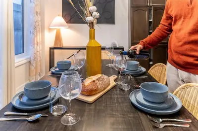 a person pouring wine at a table with a bread at Family Retreat. in Milton