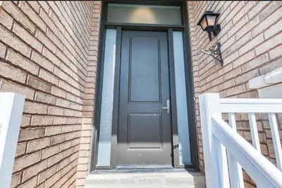 a black door on a brick building with a staircase at Beautiful Studio with Patio in Mississauga in Mississauga