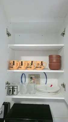 a kitchen shelf with dishes and cups and plates at Beautiful Studio with Patio in Mississauga in Mississauga