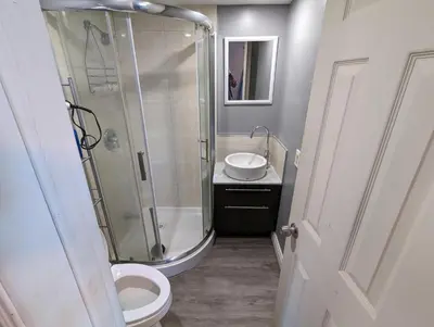 a bathroom with a shower and a toilet and a sink at Modern Tiny Wood Cottage #2 in Wasaga Beach