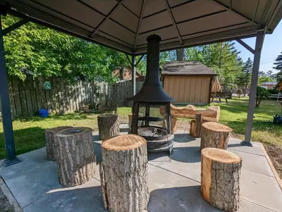 a group of logs and a grill under a tent at Modern Tiny Wood Cottage #2 in Wasaga Beach