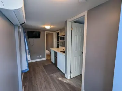 a kitchen with a white door and a counter top at Modern Tiny Wood Cottage #2 in Wasaga Beach